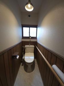 a bathroom with a toilet in a room with wooden walls at GateFuji Fujisan Station in Fujiyoshida +2 photos