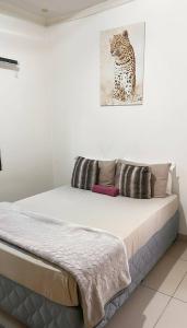 a bed in a room with a picture of a leopard at Zak Guest House in Manzini