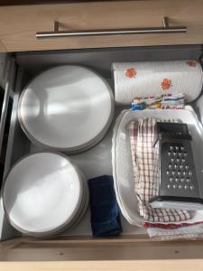 a drawer filled with plates and dishes and a sink at Escale à Villeneuve in Villeneuve-sur-Yonne
