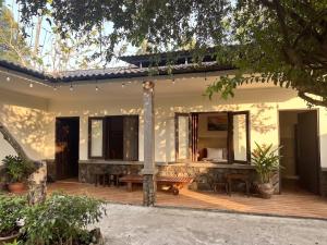 a house with a wooden deck with a mirror at Nếp Nhà Homestay in Tân Phú