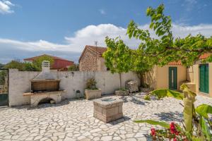 a courtyard with a stone fireplace and a fence at Traditional House in Rífion