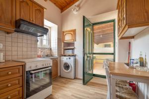 a kitchen with a stove and a washer and dryer at Traditional House in Rífion
