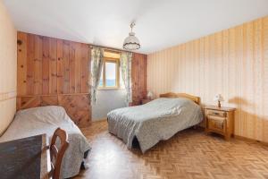 two beds in a room with wood paneled walls at Gîte Le Panorama in Rentières