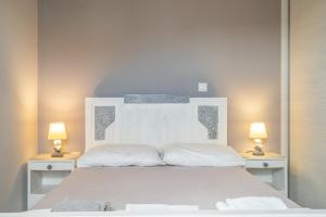 a bedroom with a white bed with two lamps at Traditional House in Rífion