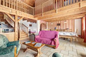 a living room with a pink chair and a table at Gîte Le Panorama in Rentières