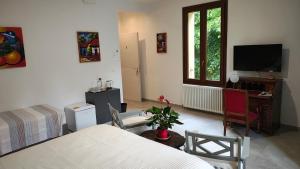 a bedroom with a bed and a desk and a tv at La Torre di Longara in Calderara di Reno