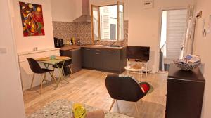 a kitchen with a table and chairs in a room at studio cosy meublé, terrasse et patio pour vélo in Rochefort