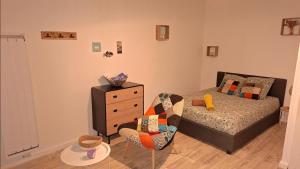 a bedroom with a bed and a chair and a dresser at studio cosy meublé, terrasse et patio pour vélo in Rochefort