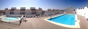 a large swimming pool with chairs and a building at Casa Nankurunaisa in Vejer de la Frontera