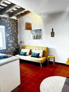 a living room with a yellow couch and a red floor at Mas Ribas Hotel i Esdeveniments in Palamós