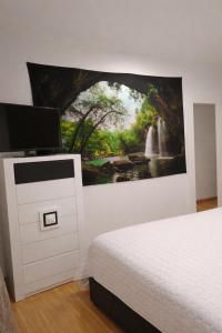a bedroom with a bed and a painting on the wall at Casa Nankurunaisa in Vejer de la Frontera +13 photos