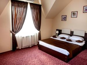 a bedroom with a large bed and a large window at Art Hotel in Kamensk-Shakhtinskiy