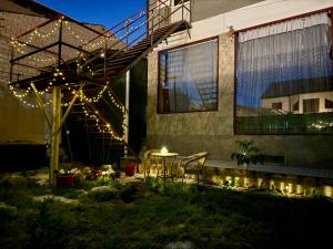a patio with a table and lights on the side of a building at Mansard 91 in Sergeli Bekati