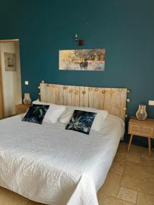 a bed with two pillows on it in a bedroom at Mas Bastide st Victor à 5 mn de Lourmarin in Puyvert