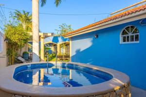 a swimming pool in front of a blue house at Amplia Habitación Doble 7, Alberca, Gym y Terraza in Mérida