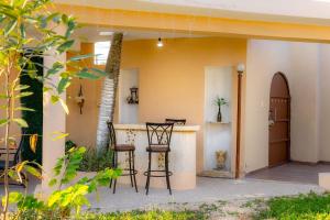 a patio with chairs and a bar in a house at Amplia Habitación Doble 7, Alberca, Gym y Terraza in Mérida