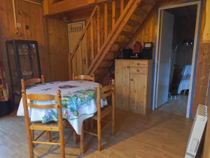 a kitchen with a table and chairs in a room at La maison bleue in Saint-André-dʼHébertot +3 photos