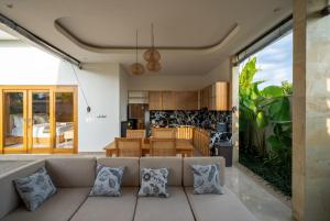 a living room with a couch and a kitchen at Suralaya Villas in Ubud