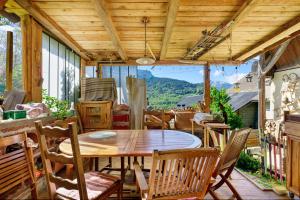 a dining room with a table and chairs on a patio at Petit chalet Chez Gaston in Saint-François-Longchamp
