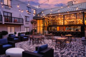 a patio with tables and chairs and a building at DoubleTree by Hilton Gainesville in Gainesville