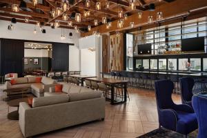 a lobby with couches and a bar with tables and chairs at DoubleTree by Hilton Gainesville in Gainesville