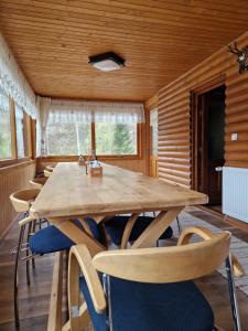 ein Esszimmer mit einem großen Holztisch und Stühlen in der Unterkunft Deer Chalet in Holda