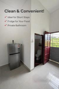 a bathroom with a refrigerator and a toilet in a room at Lot 766, Langkawi in Pulau Langkawi