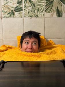 a man laying in a yellow blanket in a bathtub at Kuscheliger Zirkuswagen im Wildgarten in Witzenhausen