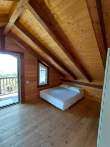 a bed in a wooden room with a large window at Sol Apartments in Durrës