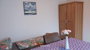 a dining room table with a vase of flowers on it at Monteurzimmer Ehmen in Wolfsburg