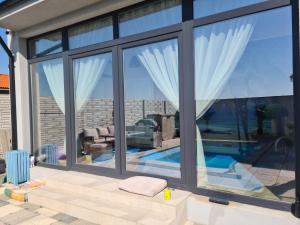 a house with large windows and a swimming pool at Garden of Silance in Cîrcea