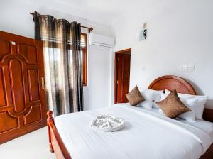 a bedroom with a large white bed with a bowl on it at Villa Dream D in Hikkaduwa