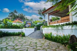 a house with a staircase leading up to a house at Suralaya Villas in Ubud