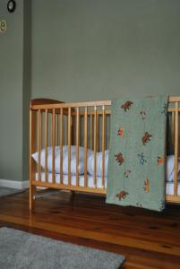 a crib in a room with a wooden floor at Pokrzepka in Spychowo