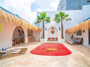 a patio with a large red rug on the ground at Harbie Villa in Seminyak