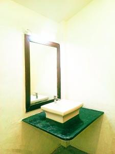 a bathroom with a sink and a mirror at The Blue Planet Long Island in Middle Andaman +3 photos