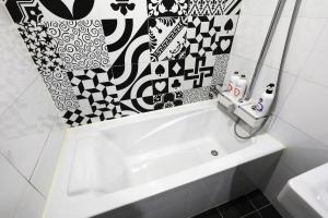 a white sink in a bathroom with black and white tiles at Selene Hotel in Seoul