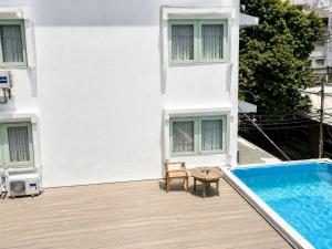 a balcony with a swimming pool next to a building at Easy Monday Pool Capsule Hotel - Old Town Bangkok in Bangkok