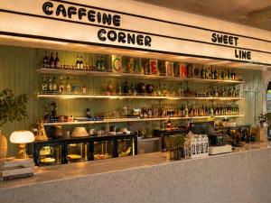 a restaurant with a counter with lots of bottles at Easy Monday Pool Capsule Hotel - Old Town Bangkok in Bangkok
