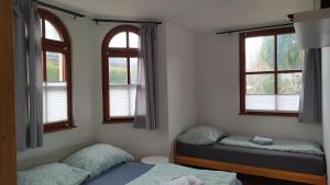 a bedroom with two beds and two windows at VILA CALLUM - výhodné dlouhodobé pronájmy v RD in Ostrava