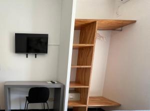 a room with a book shelf and a desk and a tv at Hotel Hollywood Convenzionato Aquafan in Riccione