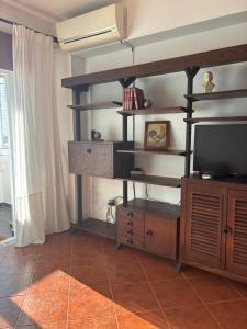 a living room with a tv and a entertainment center at T2 A 150 m de la plage in Armação de Pêra
