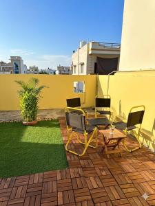 a patio with chairs and a table and grass at La Pausa Homestay in Kỳ Vĩ