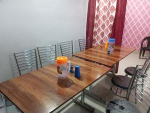 a wooden table with two chairs and two cups on it at Hotel shiva in Sar
