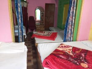 a room with three beds and a window at Hotel shiva in Sar