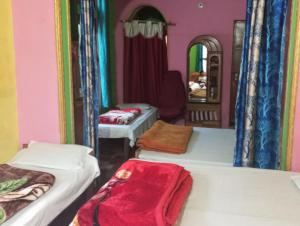 a room with three beds and a mirror at Hotel shiva in Sar +8 photos