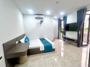 a bedroom with a bed and a desk and a tv at Anna Belle - Henry Hotel Đồi Rồng chuỗi HPT Home Hải Phòng in Hai Phong