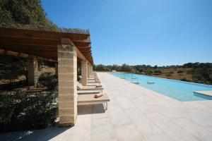 a pool with a row of chairs next to a building at Belle Son Mas Luxury Finca Hotel in Porto Cristo