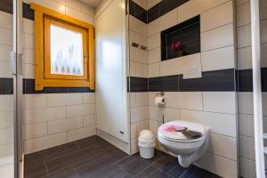 a bathroom with a toilet and a window at Bungalows am Senftenberger See in Großkoschen +5 photos