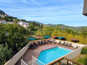 a pool on a deck with chairs and umbrellas at Virginia N101 ST2 in Grasse